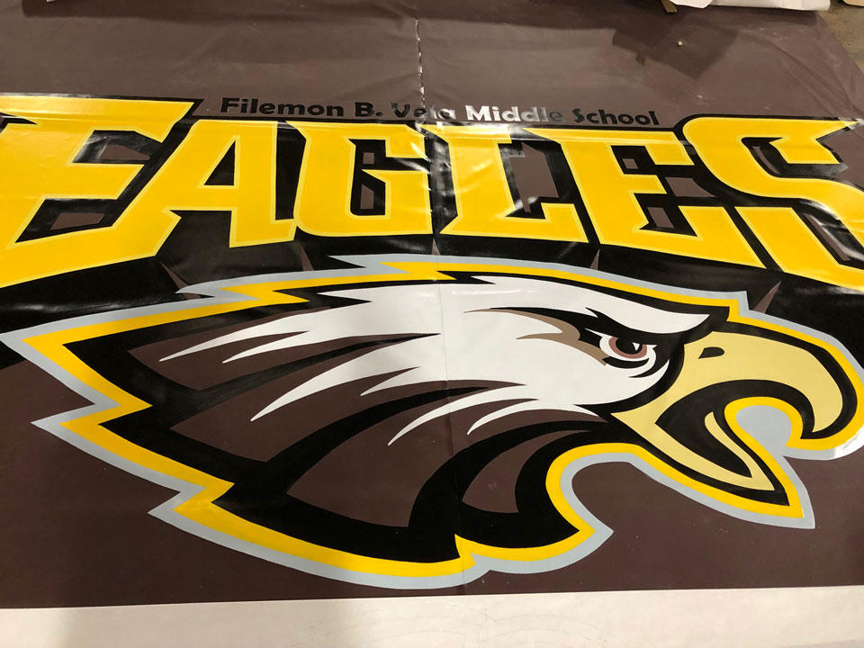 Gym floor covering with a school's eagles logo and image