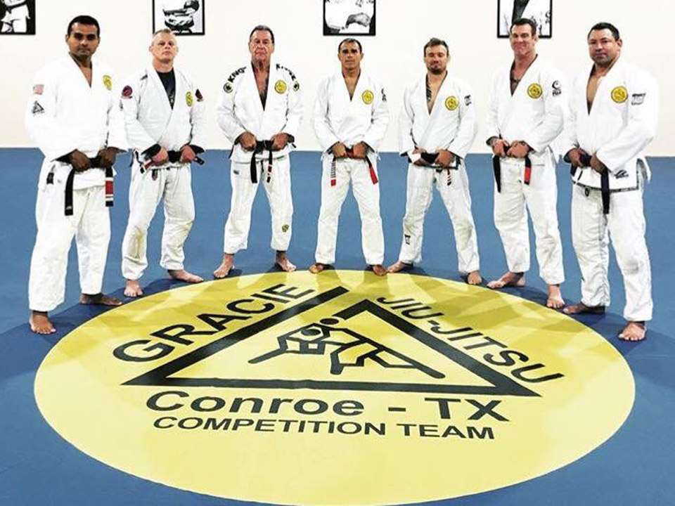 7 martial arts instructors standing on mat