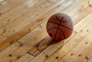 Basketball resting on a polished wooden gymnasium floor.