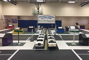 Gym set up with safety town cars and tarps.
